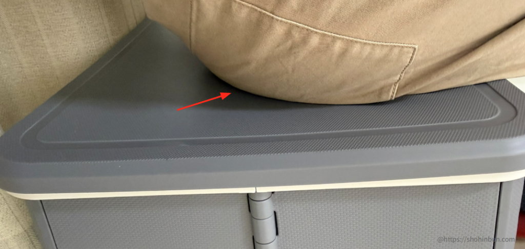スツーレ（Stoole）の上に座った際の荷重テスト。150kgの耐荷重スペックを裏付けるように、天面に大きな「たわみ」や変形が見られず、厚みのあるプラスチック構造がしっかりと体重を支えている様子を示している。